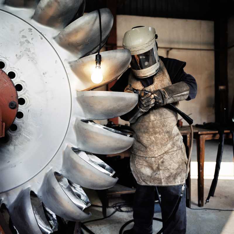 Engineer at the Khimti hydro plant works on one of its two-tonne steel turbines 