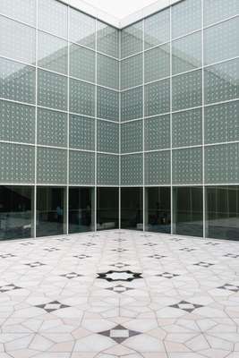 Interior courtyard where the windows and floor are adorned with geometric 'mashrabiya' patterns