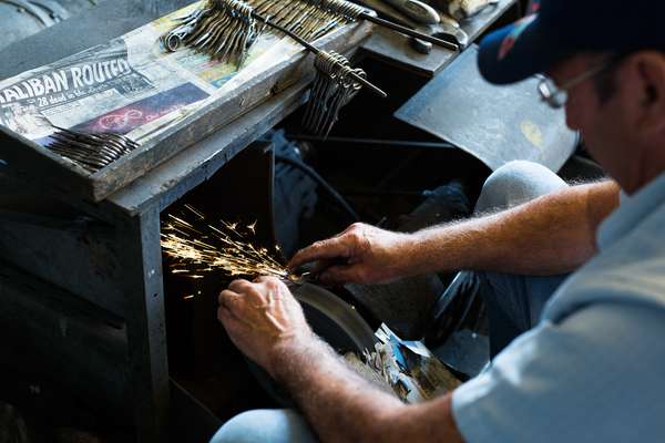 Stones at the grindstone polishing a pair of scissors