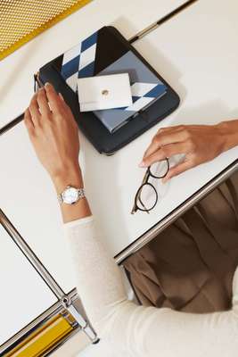 Jumper by Auralee, watch by Tudor, glasses by Lindberg, diaries by Smythson, coin purse by Ettinger 