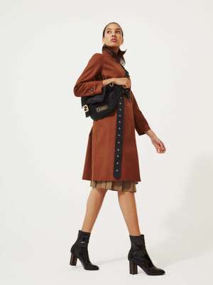 Coat by Mackintosh, skirt by Sunspel, boots by Louis Vuitton, earrings by Ana Khouri, bag by Fendi and Porter