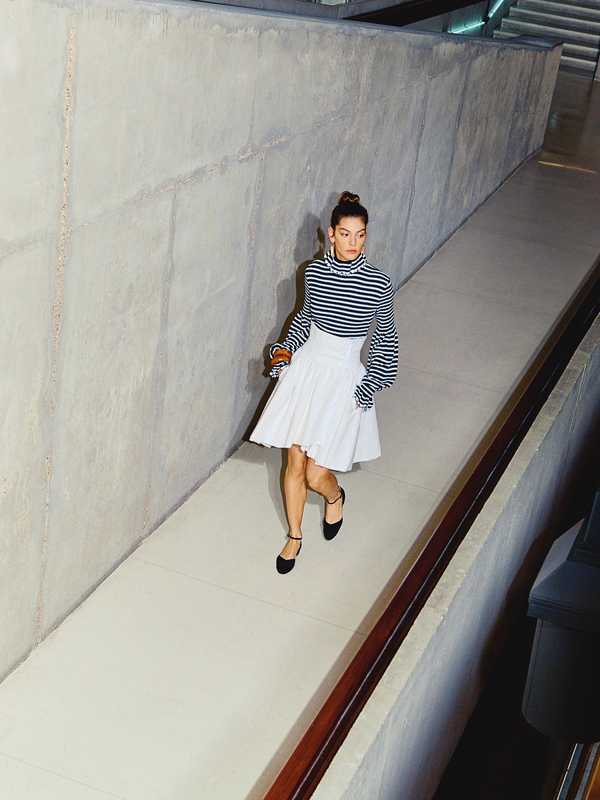 Rollneck jumper, skirt and shoes by Chanel, earrings by Celine,  bangles by Saint Laurent