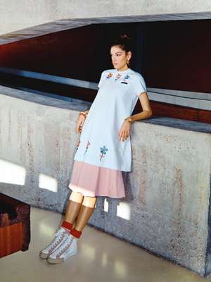 T-shirt dress, skirt, trainers and  socks by Prada, earrings by Patou, bracelets by Saint Laurent