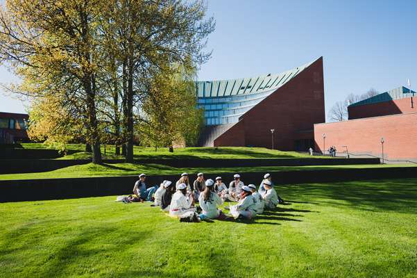 Students sitting outside Aalto University in Otaniemi, Espoo