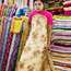 Vendor modelling fabric for wedding dress in stall at Scott Market