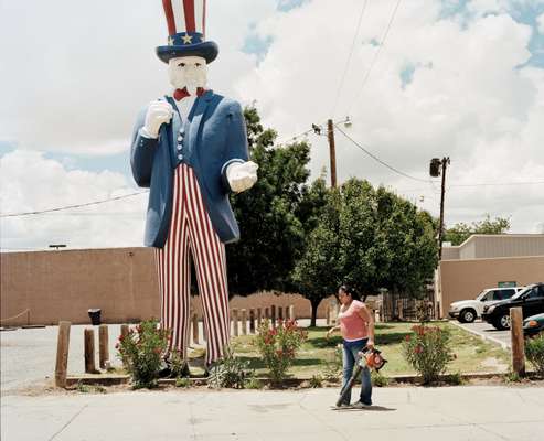 ‘Uncle Sam’ towers over a Hispanic woman, New Mexico