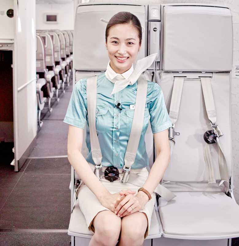 A flight attendant takes her jumpseat