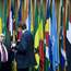 Visitors stand in front of the flags of member states in the AU headquarters
