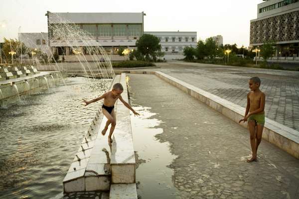 Children play in a Soviet-era fountain