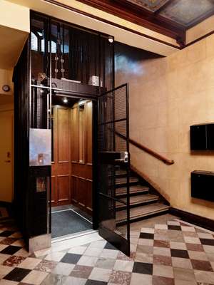 Wrought iron entrance to the wood-panelled lift in Block C