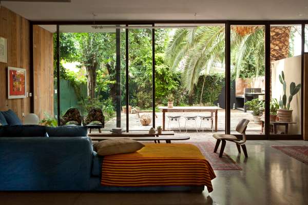 Living-room space on the open-plan lower floor looking on to the garden, complete with palm tree and parrilla (barbecue) 
