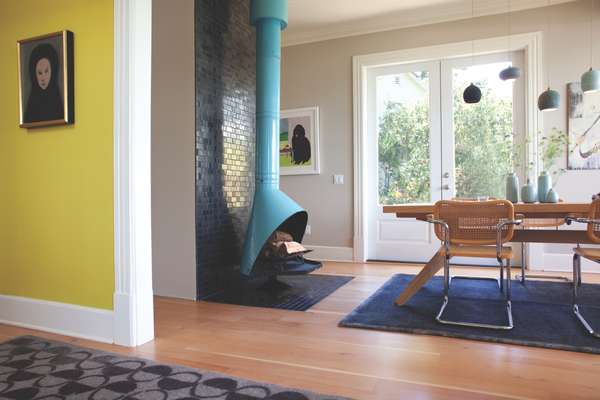 The dining room has a hanging fireplace with Heath tiles on the wall behind 