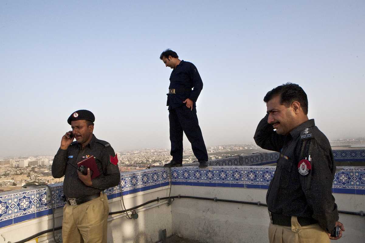 Policemen and a security guard on the roof of Karachi’s Habib Bank Plaza