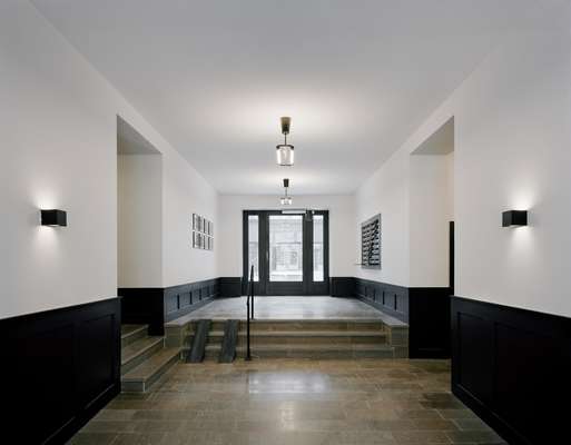 The entrance hall to Block B is a more sober affair with a polished concrete floor and a charcoal palette