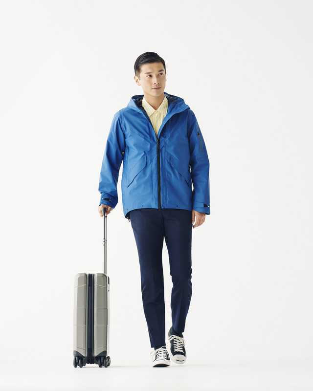Jacket by Goldwin, shirt by Markaware from Parking, trousers by Auralee, trainers by Converse, suitcase by Victorinox