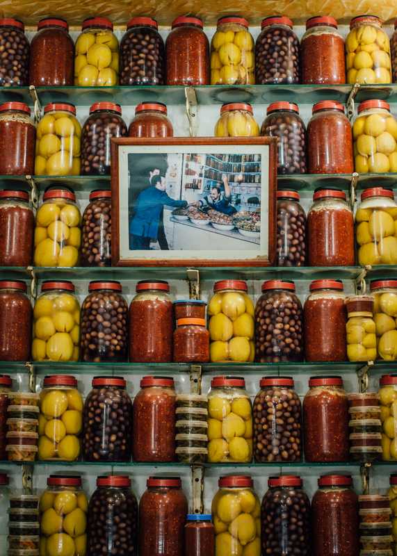 Portrait surrounded by pickled lemons and olives in the souk