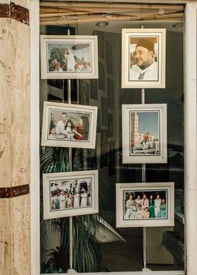 Multiple Mohammed VI portraits in the window of a Fes film developer