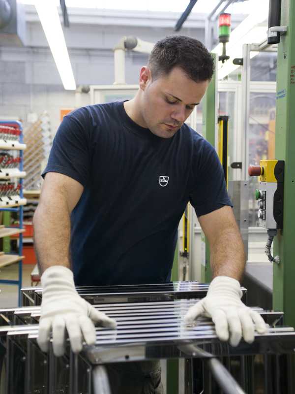 An engineer checks a stack of glass oven doors