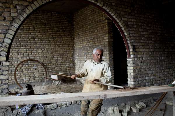 A workman crafts steel bars