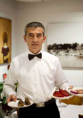 A waiter brings some mezze dishes