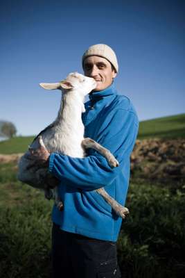 Farmer Giovanni Solerio with one white kid