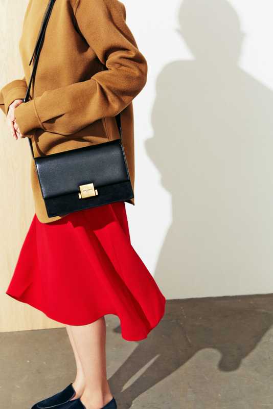 Highneck pullover by Jil Sander, skirt by Mansur Gavriel, bag by Saint Laurent by Anthony Vaccarello