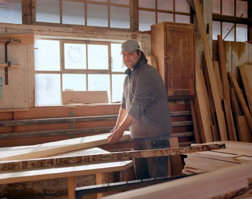 Carpenter prepares to saw and plane a board