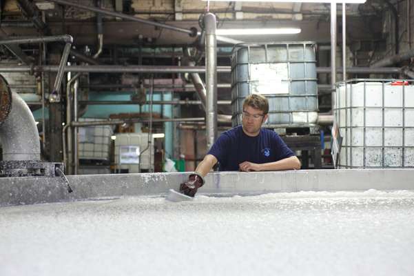 Worker checks the furnish (wet pulp) from the blending chamber