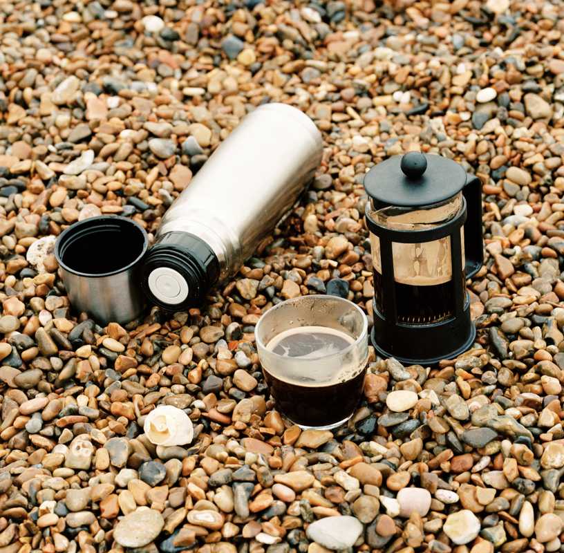 Fresh coffee brewed on the beach using hot water from the flask
