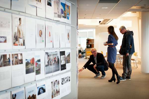 Staff looking at pages in the newsroom