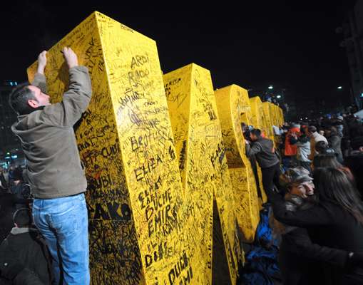 Passersby sign a new monument in Pristina, which spells out  ‘new born