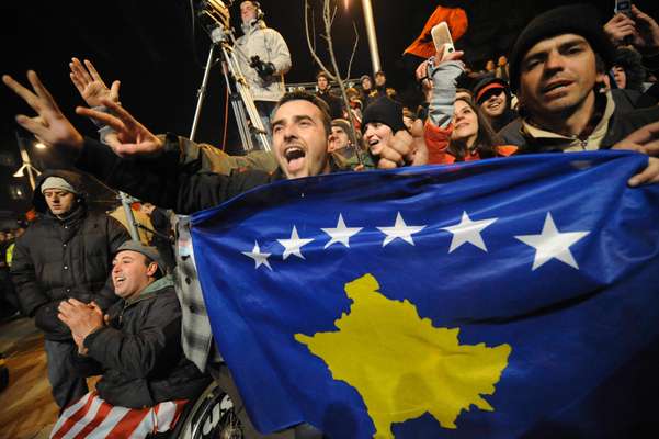 Kosovars display their new flag in the centre of Pristina