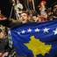 Kosovars display their new flag in the centre of Pristina