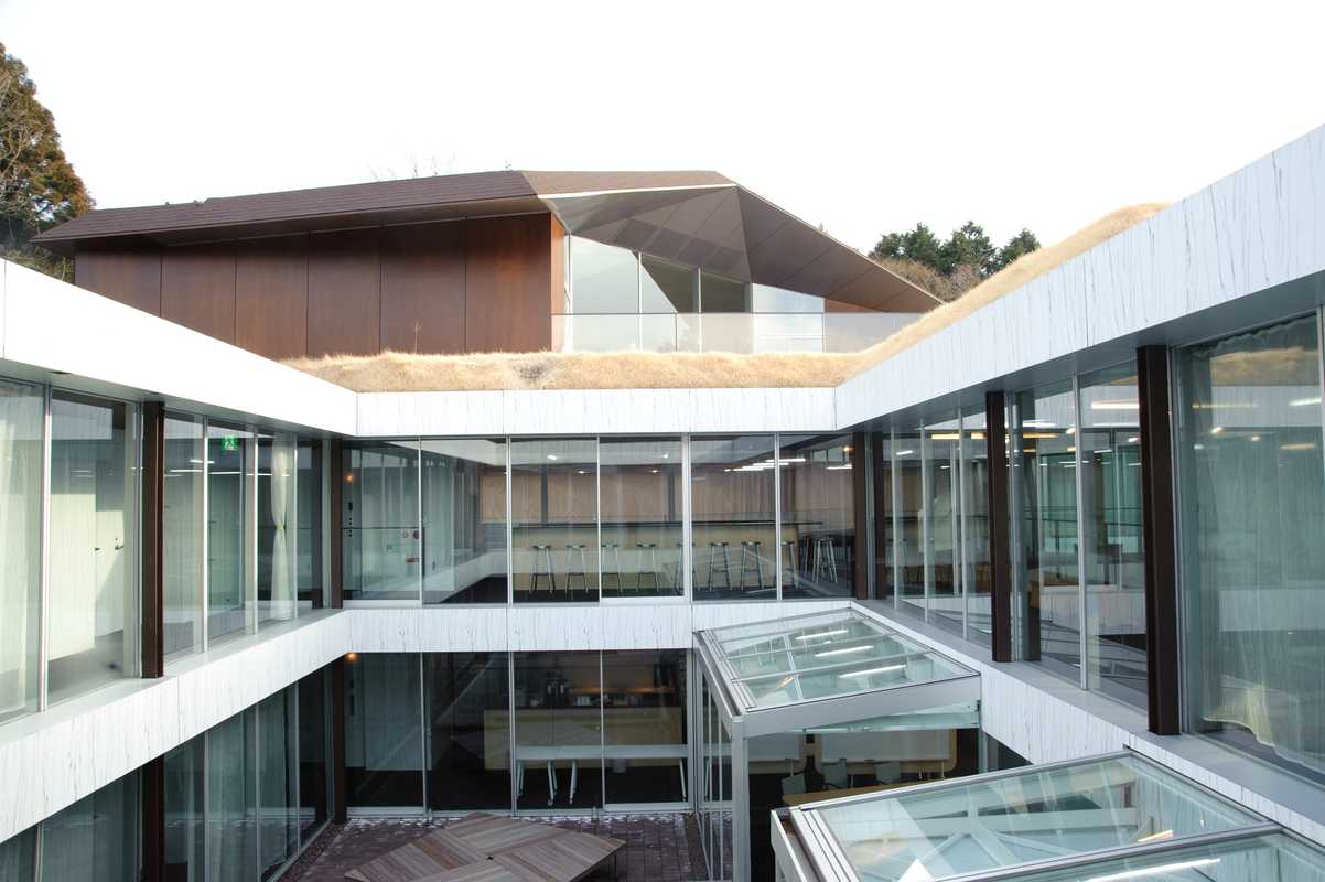 An angular roof caps the L-shaped building with two interior courtyards 