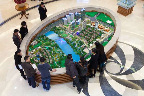 Prospective home buyers gather around a model of the Nordic City development