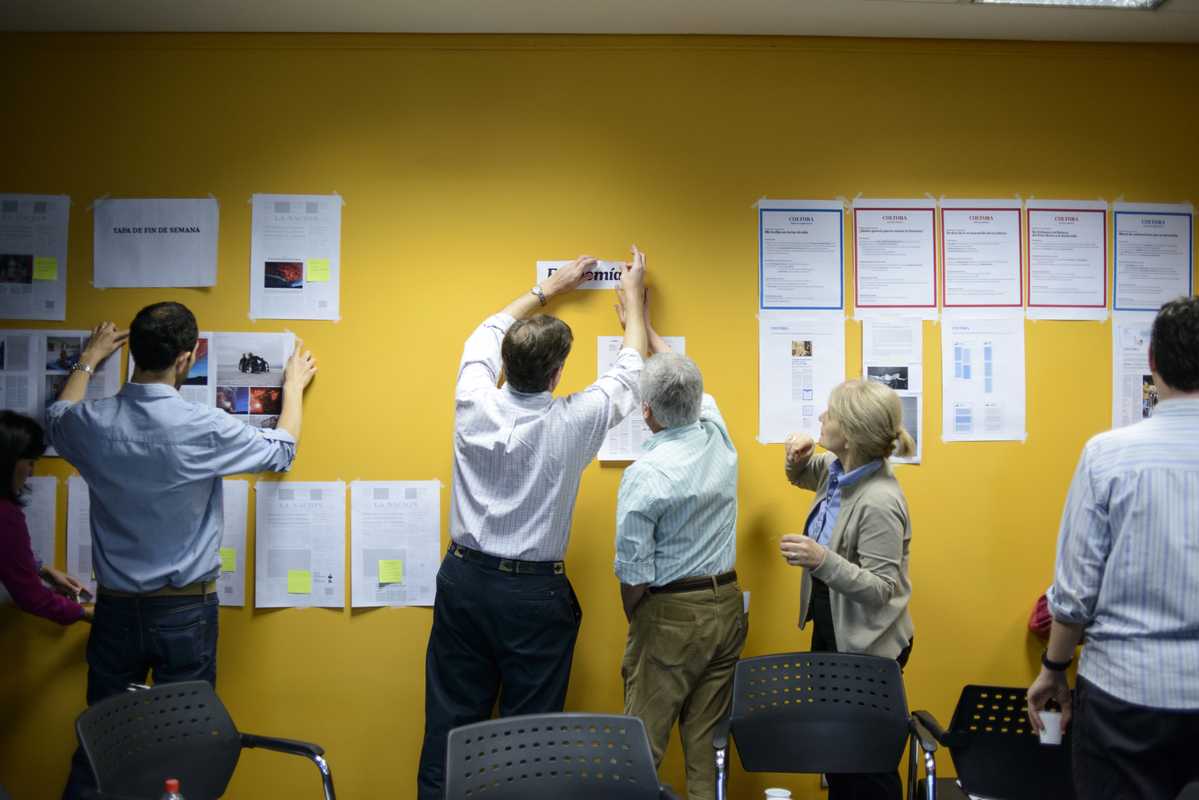 Redesign proposals are pinned to the wall during an innovation workshop