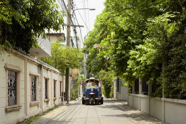 Thai tuk-tuk navigating a narrow Ari street