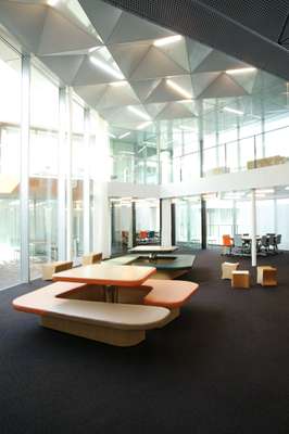 Lobby with G-shaped table and seating units. The low stools can be flipped on their side and turned into tables