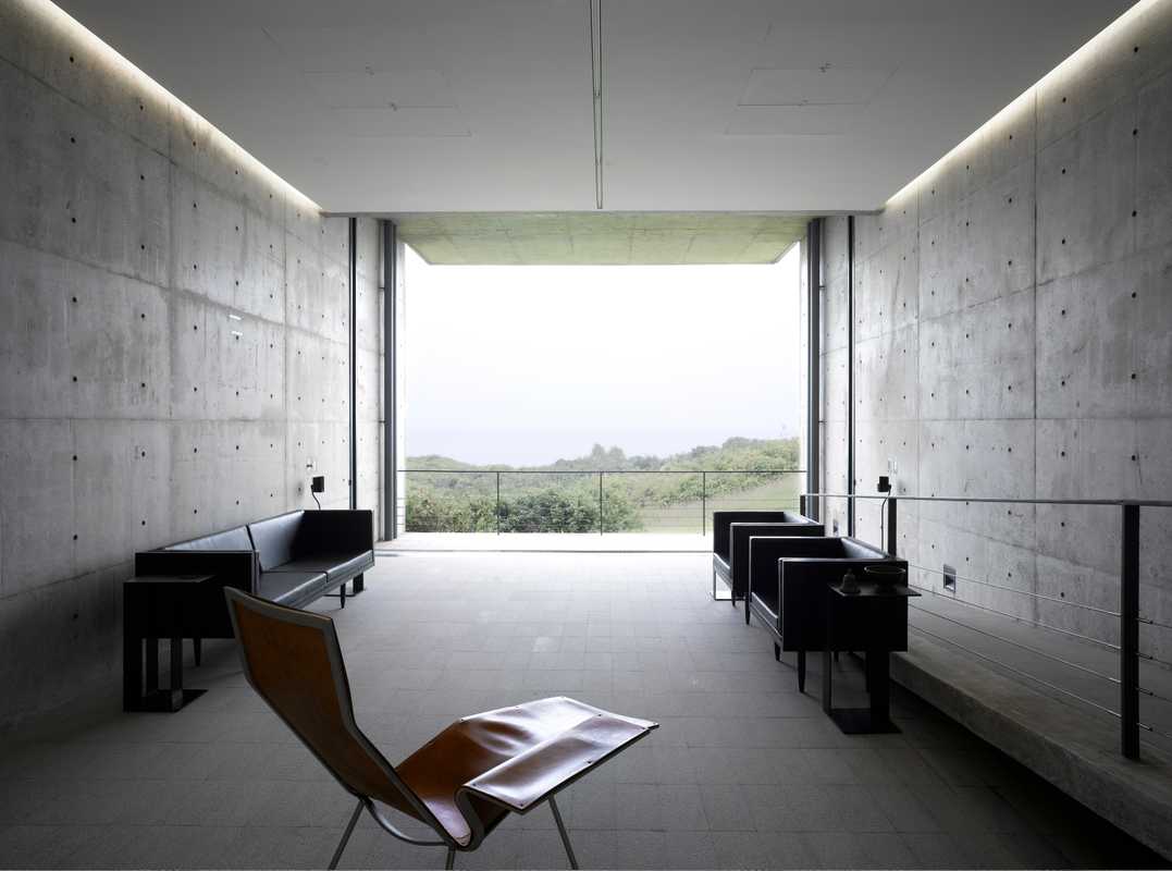 Sparse furniture and bare concrete contrasts with the exotic landscape