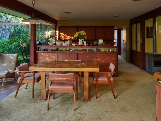 Open dining area that adjoins the kitchen; all cupboards are original