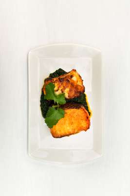 Masala sea bass topped with coriander and served on a spinach-and-mushroom base