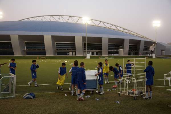 Students after evening football practice. The Aspire Dome is in the background