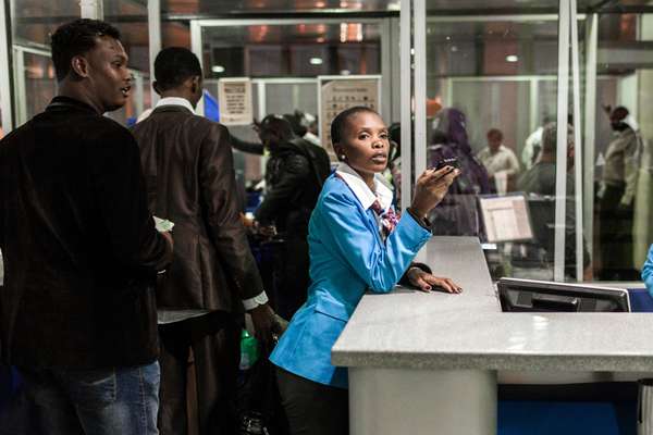 A Nairobi airport employee overseeing the passengers for flights to Somalia  
