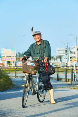 74-year-old islander Isamu Miyazato sports a chicken feather for no occasion. Why not? 