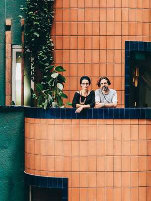 Julia Morgado (left) and Luis Calau on the exterior passageway in front of their home