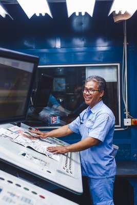 Worker inspecting the colours of the freshly printed newspaper in the printing house, located just below the ‘Kompas’ offices