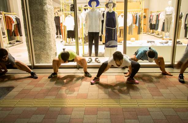 Runners stretching at a shop before heading off