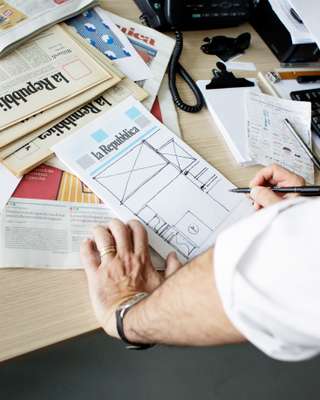 Rinaldi sketching a layout on a  front-page mock-up