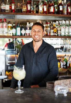 Jesse Williams mixing drinks  at his bar Paradiso