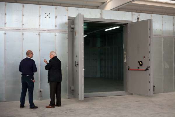 Giorgio Amedeo (right) inspects assembly of a vault on-site at a firm that stores and transports artworks in Milan